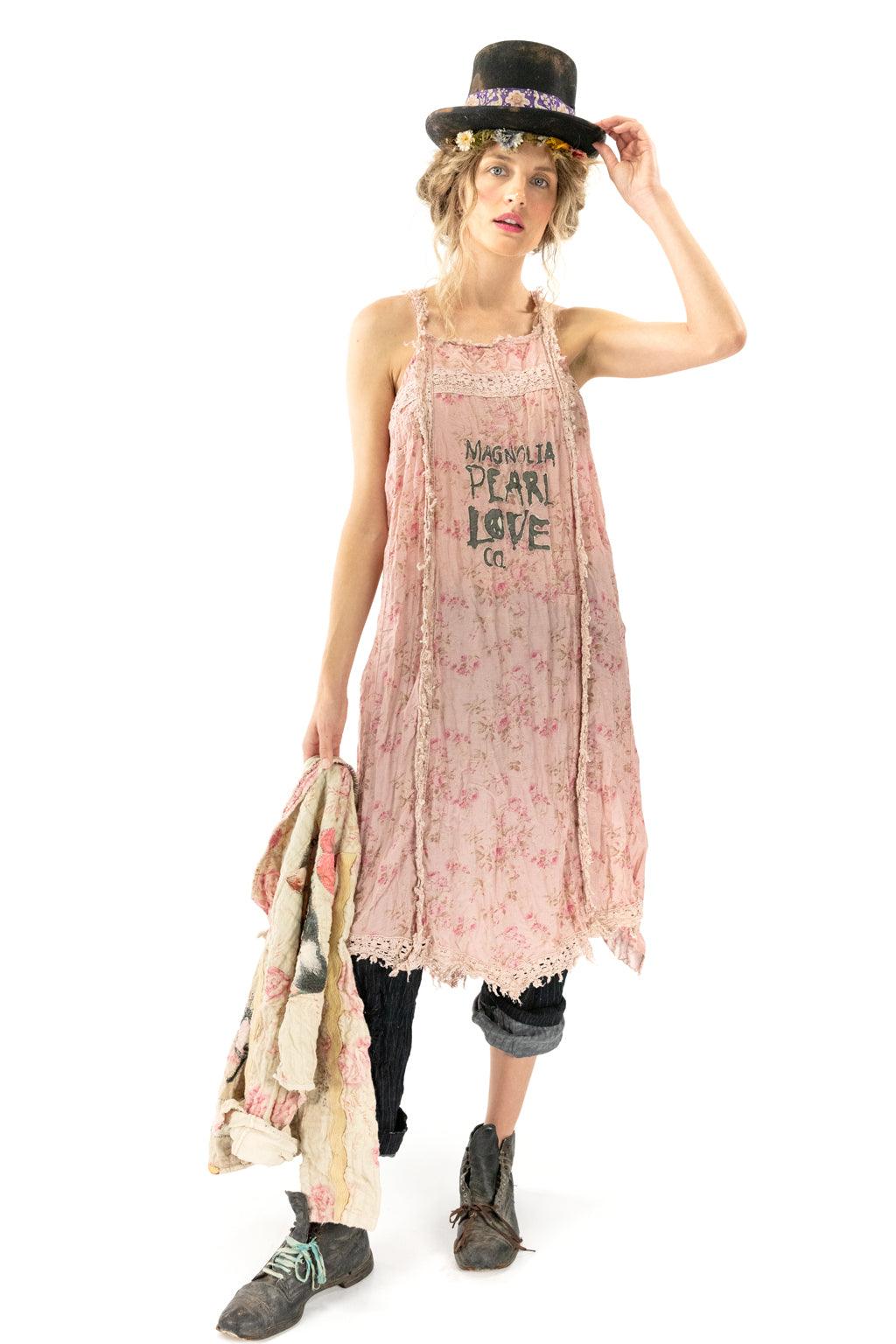 Woman in Magnolia Pearl vintage pink floral dress and artisan top hat, whimsical boho style