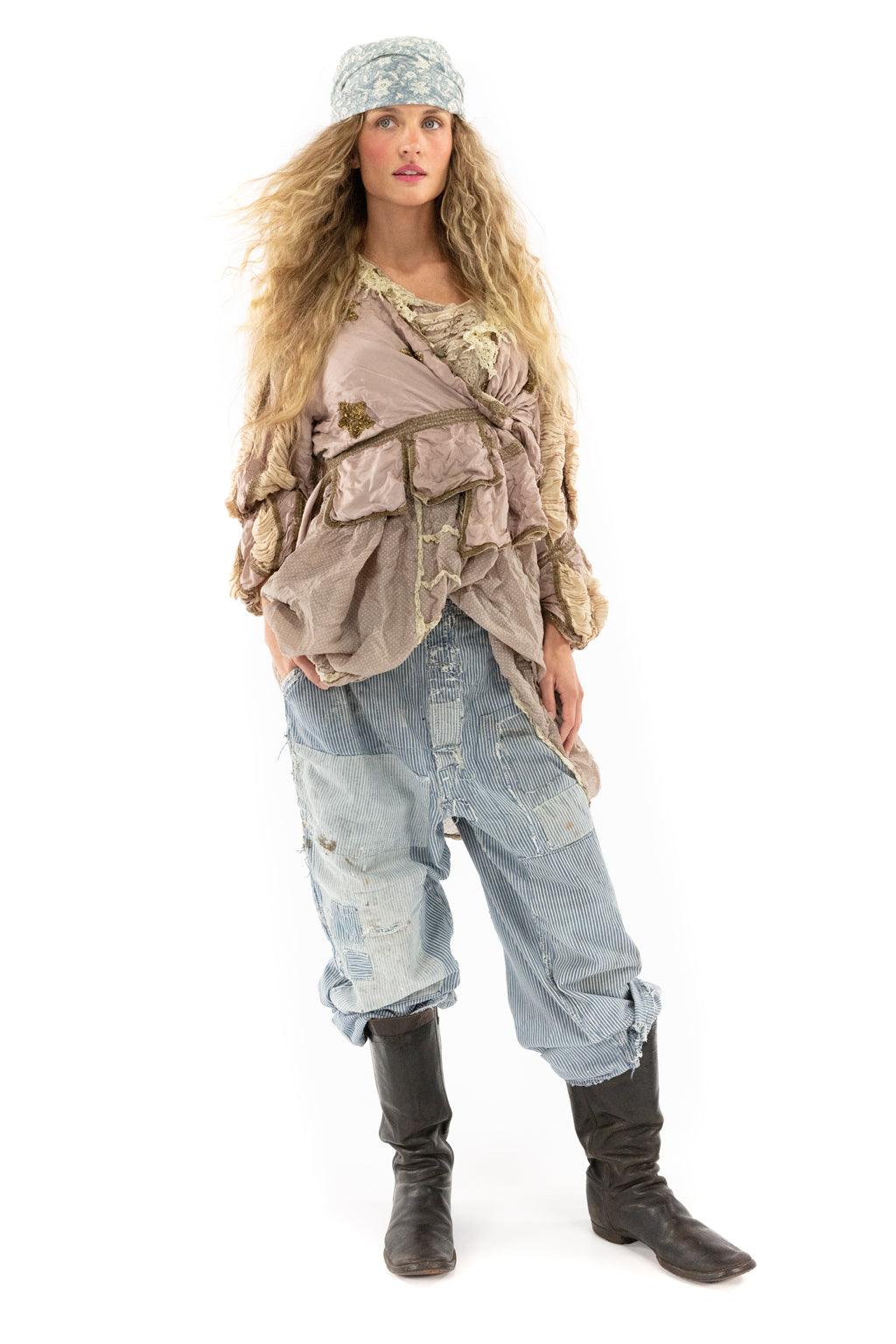 Woman in Magnolia Pearl lilac ruffled artisan jacket, vintage-style patched pants, and boots