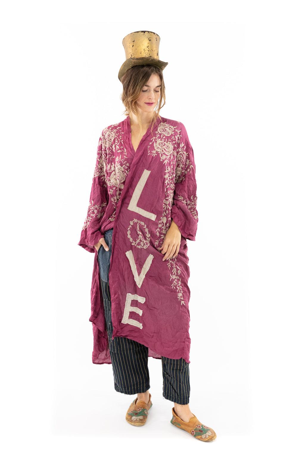 Magnolia Pearl woman in whimsical vintage magenta love kimono jacket, artisan style, gold hat