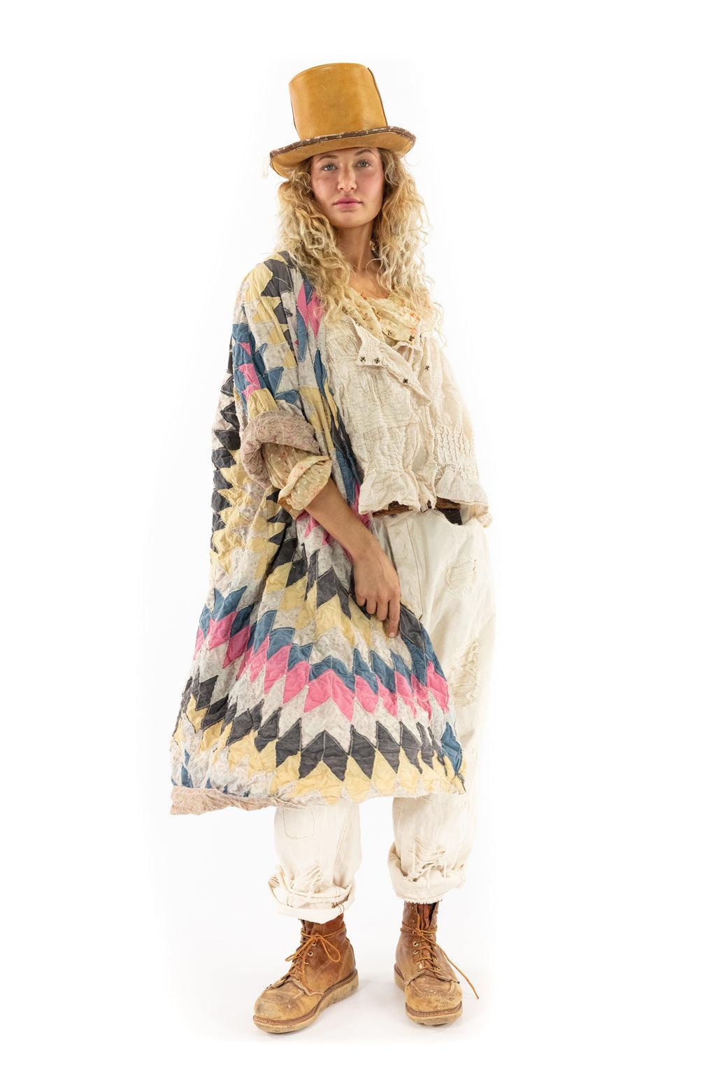 Woman in Magnolia Pearl artisan quilted jacket, vintage top, cream pants, and tan top hat