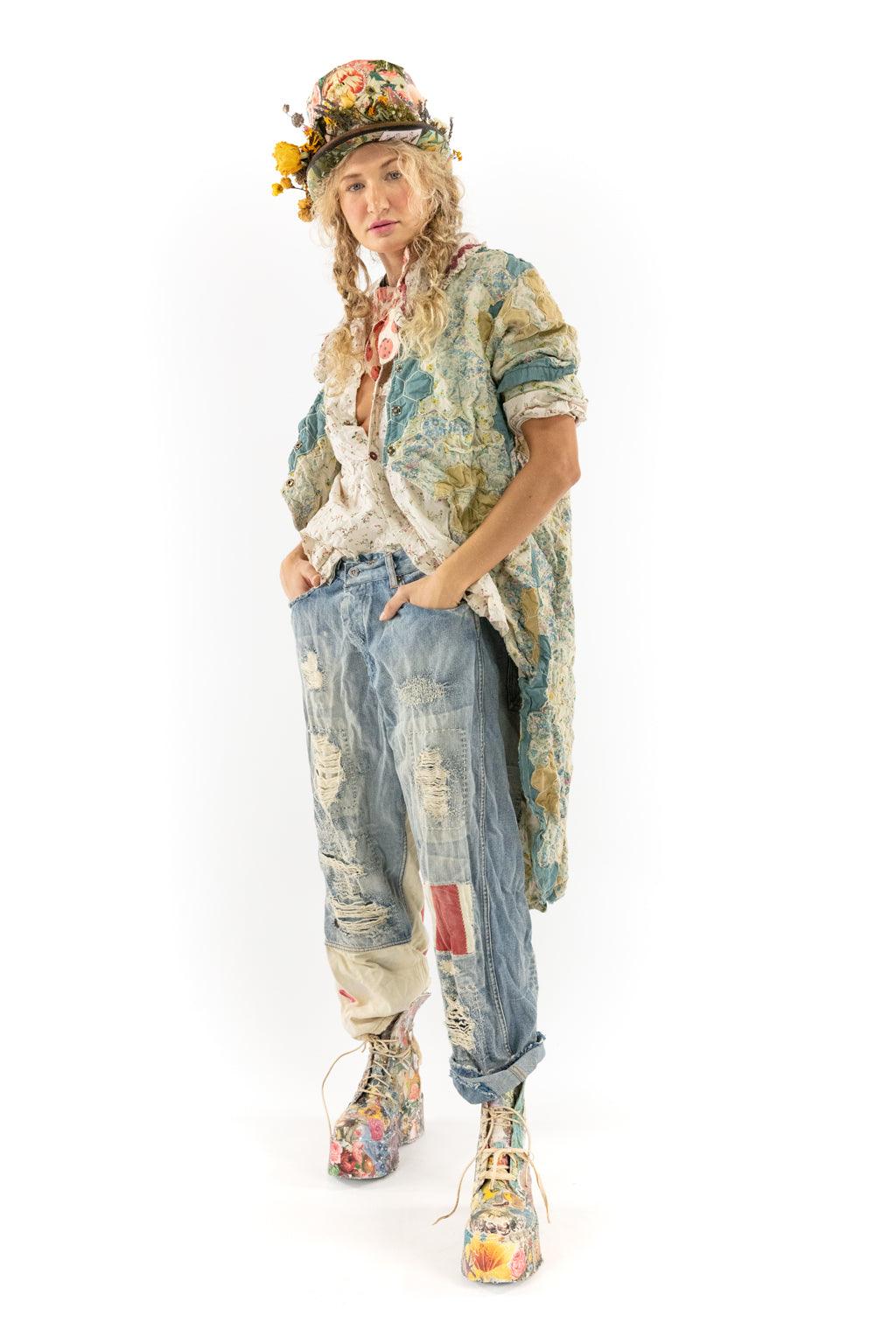 Woman in Magnolia Pearl artisan vintage patchwork jacket and distressed jeans, floral hat, whimsical style